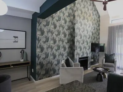 a living room with a wall with a floral wallpaper at Sanddrif Stellenbosch Guest Farm in Stellenbosch