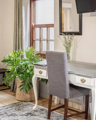 an office desk with a chair and a mirror at Olive Tree Boutique Hotel in Paarl