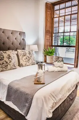 a bedroom with a large bed and a window at Olive Tree Boutique Hotel in Paarl