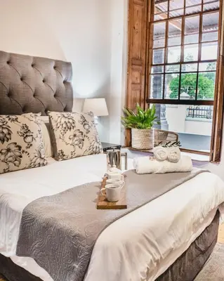 a bedroom with a large bed and a window at Olive Tree Boutique Hotel in Paarl