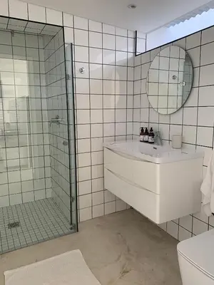 a bathroom with a shower and a sink and a mirror at Gite in Franschhoek