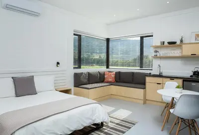 a bedroom with a bed and a couch and a table at Gite in Franschhoek
