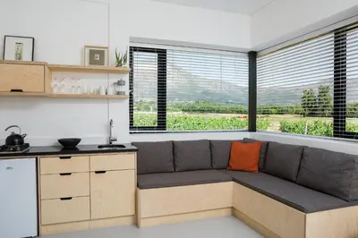a kitchen with a couch in a room with windows at Gite in Franschhoek