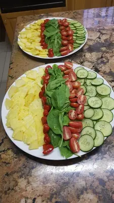 two plates of food on a table with cucumbers and tomatoes at Besigheim in Stellenbosch