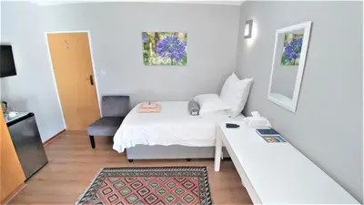 a small room with a bed and a desk at Besigheim in Stellenbosch