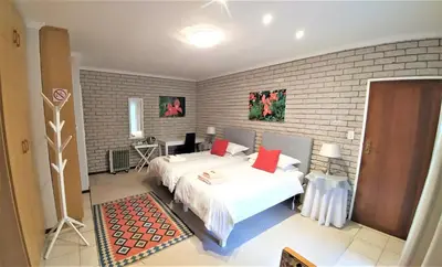 a bedroom with two beds and a brick wall at Besigheim in Stellenbosch