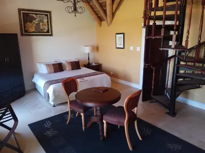 a bedroom with a bed and a table and chair at Ridgemor Villa in Somerset West