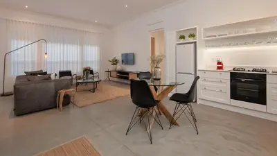 a kitchen and living room with a table and chairs at Perla in Hermanus