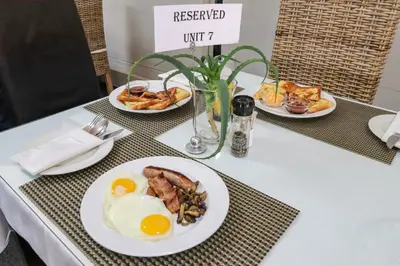 a table with three plates of breakfast food on it at Whale Coast All-Suite-Hotel - DCC Hotel Group in Hermanus