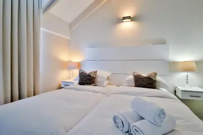 a bedroom with two beds with towels on them at Whale Coast All-Suite-Hotel - DCC Hotel Group in Hermanus