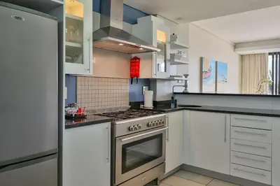 a kitchen with white cabinets and an oven at Whale Coast All-Suite-Hotel - DCC Hotel Group in Hermanus