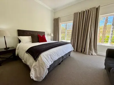 a bedroom with a large bed and a window at Charming Villa in Stellenbosch