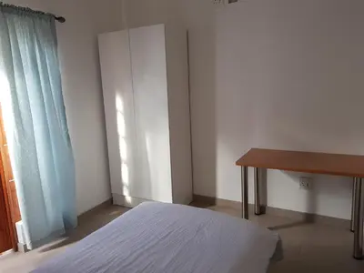 a bedroom with a bed and a desk and a window at Fama Lodge Single Rooms in Cape Town