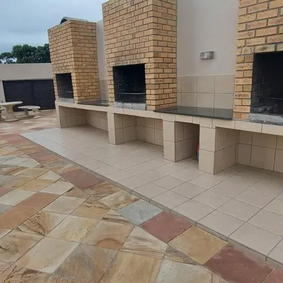a patio with a brick fireplace in a building at Ocean View Luxury Self-Catering in Strand