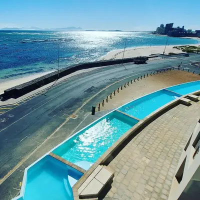 an overhead view of a swimming pool next to the ocean at Ocean View Luxury Self-Catering in Strand