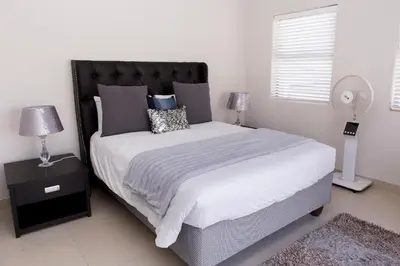 a bedroom with a large bed and a fan at MLMK Property 30 in Richwood