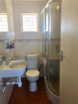 a bathroom with a toilet and a sink and a shower at Zeezicht 303 in Bloubergstrand