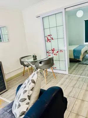 a living room with a blue couch and a glass table at Modern secure apartment in Strand - Little Greece in Strand