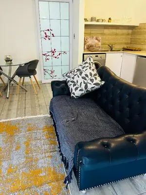 a black leather couch in a kitchen with a table at Modern secure apartment in Strand - Little Greece in Strand