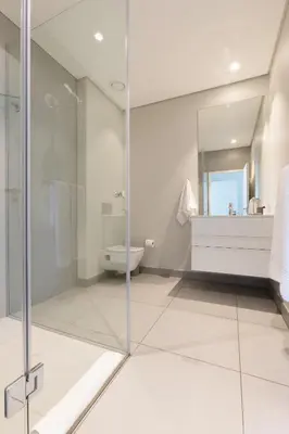 a bathroom with a glass shower and a sink at Axis Luxury Apartments by Century City Hotels in Cape Town