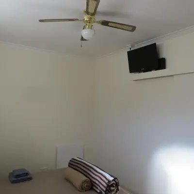 a ceiling fan in a living room with a couch at Cape Oasis Guesthouse in Bloubergstrand