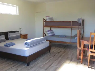 a room with two bunk beds and a table at Cape Oasis Guesthouse in Bloubergstrand
