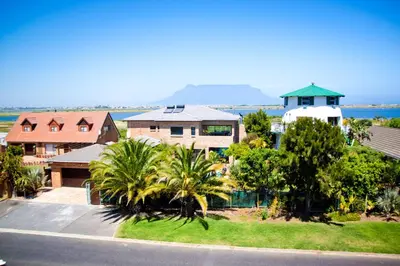 an aerial view of a house with palm trees at Cape Oasis Guesthouse in Bloubergstrand