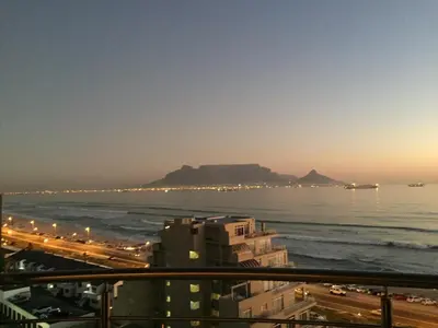a view of the ocean from a balcony of a building at Ocean View B1001, Blouberg in Bloubergstrand