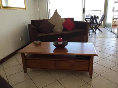 a living room with a couch and a coffee table at Ocean View B1001, Blouberg in Bloubergstrand