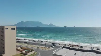 a view of the beach and the ocean from a building at The Waves Blouberg Beach Apartments in Bloubergstrand