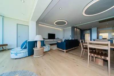 a living room with a blue couch and a table at Bayview 303 in Hermanus