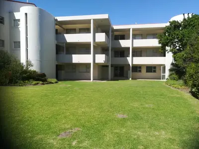 an apartment building with a large lawn in front of it at Bayview 303 in Hermanus