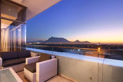 a room with a balcony with a view of the city at The Residences at Crystal Towers in Cape Town