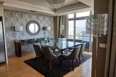 a dining room with a glass table and chairs at The Residences at Crystal Towers in Cape Town