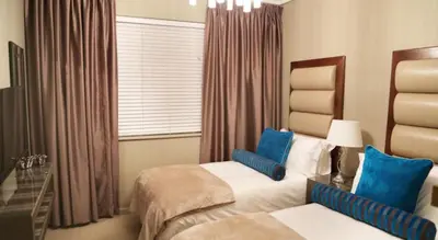a hotel room with two beds and a window at The Residences at Crystal Towers in Cape Town