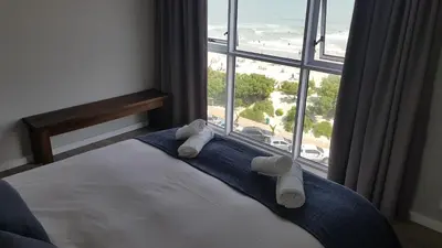 a bedroom with a bed with a view of the beach at 604 St Tropez in Strand