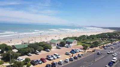 a parking lot at the beach with cars parked at 604 St Tropez in Strand