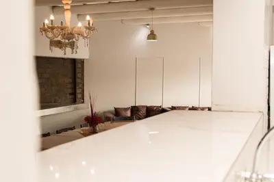 a living room with a white table and a chandelier at Mauya Guesthouse in Kuilsrivier