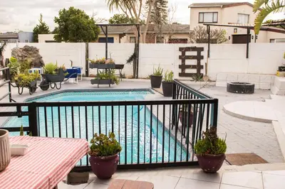 a swimming pool with potted plants on a balcony at Mauya Guesthouse in Kuilsrivier
