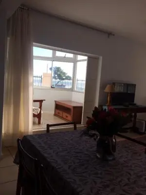 a bedroom with a bed with a table and a window at Romilly Beach Apartment in Strand