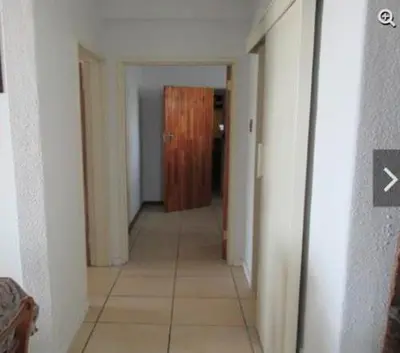 a hallway with a door in a room with a tile floor at Romilly Beach Apartment in Strand