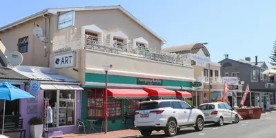 a street with cars parked in front of a building at Zzzone Boutique Hostel in Hermanus