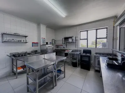 a large kitchen with stainless steel counters and appliances at Zzzone Boutique Hostel in Hermanus