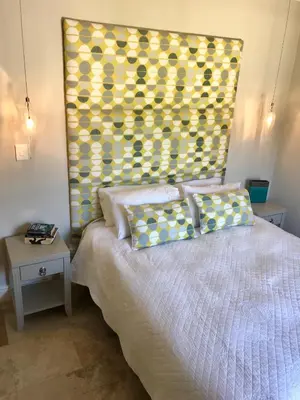 a bedroom with a bed with a yellow headboard at Maison Malherbe in Franschhoek