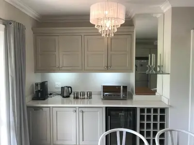 a kitchen with white cabinets and a chandelier at Maison Malherbe in Franschhoek