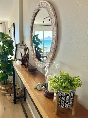 a mirror on top of a table with plants at Abode Africa in Bloubergstrand