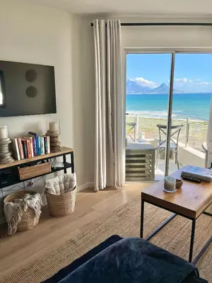 a living room with a view of the ocean at Abode Africa in Bloubergstrand