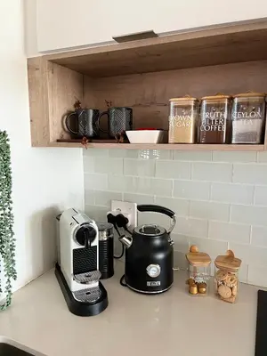 a kitchen counter with a coffee maker and a toaster at Abode Africa in Bloubergstrand