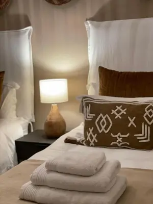 a bedroom with a bed with a pillow and a lamp at Abode Africa in Bloubergstrand