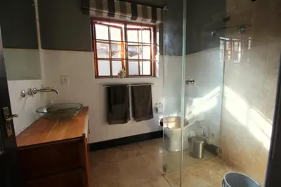 a bathroom with a sink and a glass shower at The Bergzicht Guest Suite in Cape Town